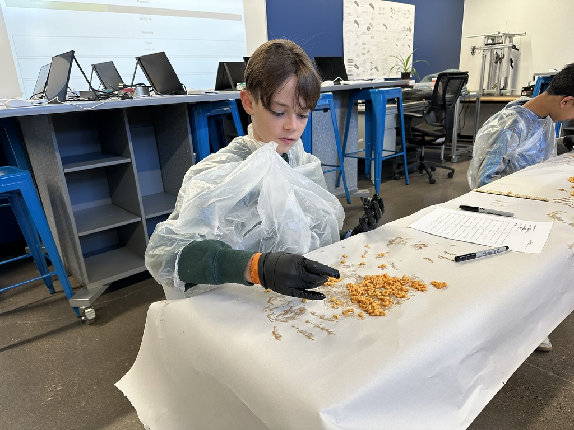 An NPA data scientist sorting and counting pasta letters at a lab bench.